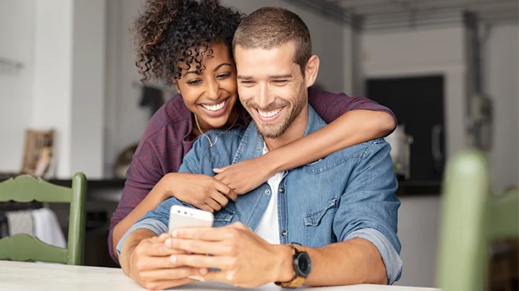 Casal olhando os descontos no celular